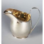 A PLAIN MILK JUG with reeded edge and handle. 5ins high. Birmingham 1930.