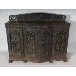 A GOOD 19TH CENTURY BURMESE CARVED AND PIERCED SIDE CUPBOARD, pierced back rail, the shaped front