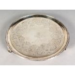 A GEORGE III CIRCULAR ENGRAVED WAITER, crested with beaded rim on three feet.7.5ins diameter. London