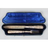 A PAIR OF VICTORIAN FRUITING VINE KNIFE AND FORK, in a fitted case. Sheffield 1884. Maker: