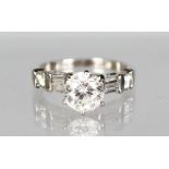 A PLATINUM SET DIAMOND RING with central stone of 1.4cts and baguette diamond shoulders, total