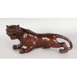 A JAPANESE BRONZE ROARING TIGER, with dark patina, incised stripes. 12ins long x 6.5ins high.