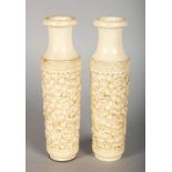 A PAIR OF CHINESE IVORY VASES, carved with scrolls and dragons. 5ins high.
