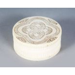 A SMALL CARVED IVORY CIRCULAR BOX AND COVER. 2.75ins.