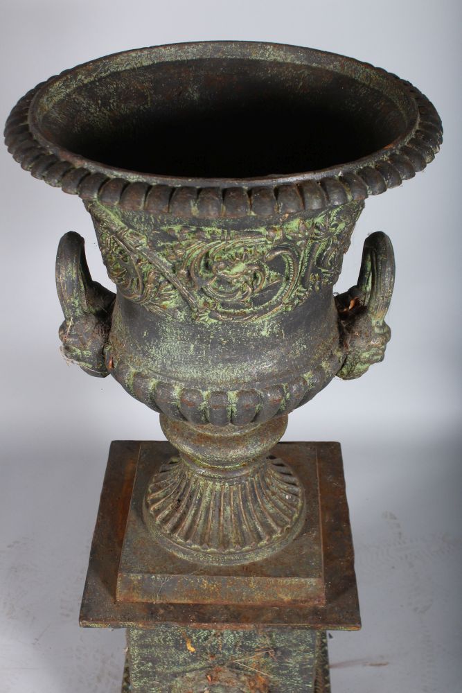 A VICTORIAN CAST IRON URN SHAPED TWO-HANDLED VASE ON STAND with mask handles. 3ft 8ins high - Image 2 of 2