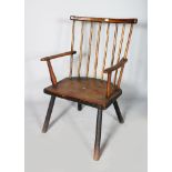 AN 18TH CENTURY OAK AND ELM SPINDLE BACK ARMCHAIR with solid seat and rustic legs.