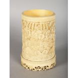 A CHINESE CANTON CARVED IVORY BRUSH POT, carved with figures, trees and buildings. 2.75ins