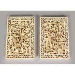 A GOOD PAIR OF CHINESE CARVED IVORY PLAQUES, with pierced borders and carved with many figures,