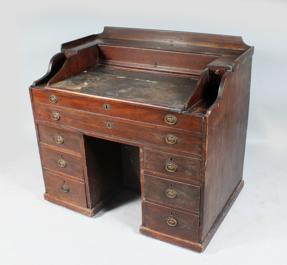 A GEORGIAN MAHOGANY RENT DESK , the top with rising writing surface, one long drawer, two drawers to