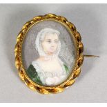 AN 18TH CENTURY OVAL PORTRAIT MINIATURE of a lady with a veil and green dress, mounted as a