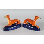 A PAIR OF STAFFORDSHIRE WHIPPET PEN HOLDERS on a blue base. 6ins long.