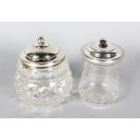 TWO SILVER TOP GLASS JAM JARS.