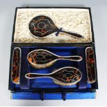 A TORTOISESHELL AND SILVER FIVE PIECE DRESSING TABLE SET, in a fitted leather case.