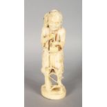 A CHINESE CARVED IVORY FIGURE OF A MAN carrying a broom. Signed Red label. 7.5ins high.
