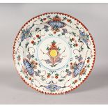 A DUTCH DELFT POLYCHROME CHARGER, EARLY-MID 18TH CENTURY, painted with a central flower, the