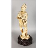 A LARGE JAPANESE CARVED IVORY FIGURE OF A HUNTER, a dog by his side, on a wooden stand. 15ins high.
