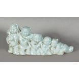 A CHINESE PORCELAIN BRUSH REST, depicting graduated children in a line. 3.5ins x 8ins long.