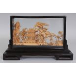 A 20TH CENTURY CHINESE CORK CARVING, in a wood and glass frame supported on a fitted rectangular