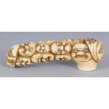 AN EARLY 20TH CENTURY SIGNED JAPANESE IVORY CANE HANDLE, carved with a variety of Noh masks, the rim