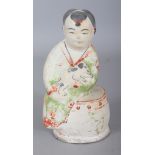 A CHINESE MING DYNASTY CIZHOU POTTERY FIGURE OF A BOY, together with a fitted box, the boy seated on