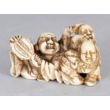 A JAPANESE MEIJI PERIOD TRIANGULAR SECTION IVORY NETSUKE, pierced and carved in the form of Hotei in