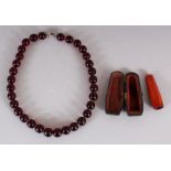 A ‘CHERRY AMBER’ NECKLACE, weighing approx. 63.1gm, composed of spherical beads, each bead approx.