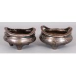 AN UNUSUAL PAIR OF 19TH CENTURY CHINESE SILVERED BRONZE TRIPOD CENSERS, one weighing 365gm, the