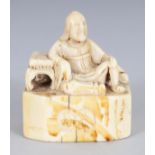 A RARE 18TH CENTURY JAPANESE EDO PERIOD IVORY NETSUKE, carved in the form of a man reclining against
