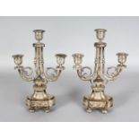 A GOOD PAIR OF LOUIS XVI DESIGN PLATED THREE LIGHT CANDLESTICKS of classical form. 11ins high.