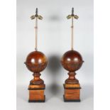 A PAIR OF 20TH CENTURY CARVED WOOD SPHERICAL TABLE LAMPS, on square plinths. 2ft 6ins high (