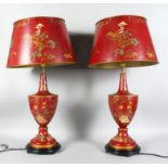 A PAIR OF RED TOLE WARE LAMPS AND SHADES. 2ft 8ins high.