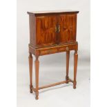 A 19TH CENTURY CONTINENTAL OLIVE WOOD TWO DOOR CABINET ON STAND, with starburst inlaid motifs, the