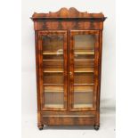 A 19TH CENTURY FRENCH MAHOGANY BOOKCASE, with a moulded cornice over a pair of glazed doors,