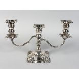 A THREE LIGHT SILVER CANDLESTICK with loaded base. 9ins high.