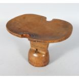 A KENYAN HEADREST, the dished shape top having metal stud work decoration. 10ins wide.