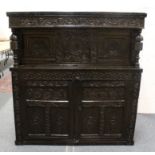 A 17TH-18TH CENTURY OAK COURT CUPBOARD WITH CARVED DECORATION, two small carved doors above two