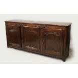 A GOOD 18TH CENTURY OAK DRESSER BASE, with twin plate top, floral carved frieze, three panelled