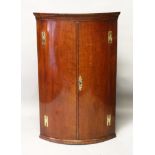 A GEORGE III MAHOGANY BOWFRONT HANGING CORNER CABINET, the interior with three shelves and three