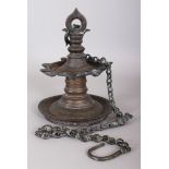 A 19TH CENTURY SOUTH INDIAN THOOKKUVILAKKU BRONZE HANGING OIL LAMP, with chain, 10in high not