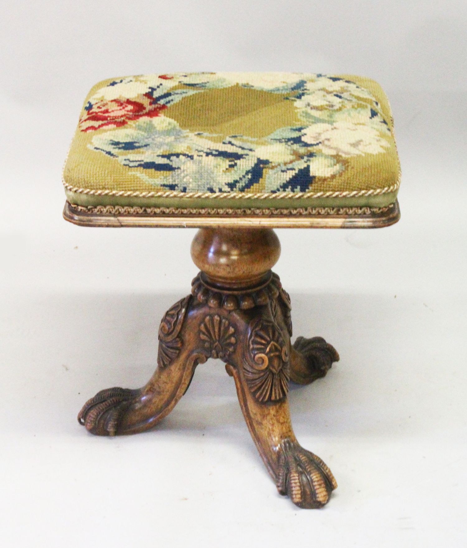 AN EARLY 20TH CENTURY WALNUT REVOLVING MUSIC SEAT, with needlework upholstered seat, on a turned