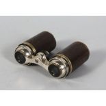 AN UNUSUAL PAIR OF FOLDING OPERA GLASSES, housed in a leather bound cylinder. 4.5ins long.