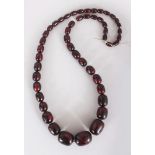 A ‘CHERRY AMBER’ NECKLACE, weighing approx. 130gm, composed of graduated oval beads, approx. 33in
