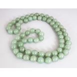 A JADE-LIKE GREEN HARDSTONE NECKLACE, composed of spherical beads, approx. 28in long.