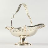 A PIERCED OVAL CAKE BASKET with swing handle. Birmingham 1905.