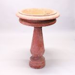 A LARGE, POSSIBLY GRANITE, CIRCULAR FONT-BIRDBATH with turned stem and base. 3ft 2ins high x 2ft