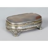 AN AGATE TOP CONTINENTAL SILVER BOX, supported on four claw feet. 5ins wide.