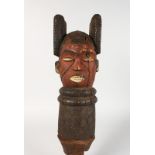 A CARVED TRIBAL HEAD with painted face. 10ins long.