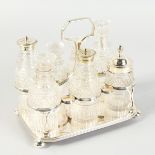 AN EIGHT BOTTLE CRUET, two with silver tops.