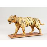 A VICTORIAN AUTOMATON ANIMAL "TIGER" WITH NODDING HEAD, on a wooden base with wheels. 17.5ins long.