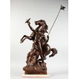 A LARGE BRONZE GROUP, YOUNG MAN WITH MARLEY REARING HORSE, standing on a square base. 25ins high.